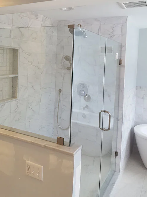 Bathroom renovation with frameless glass shower, marble tile and freestanding tub