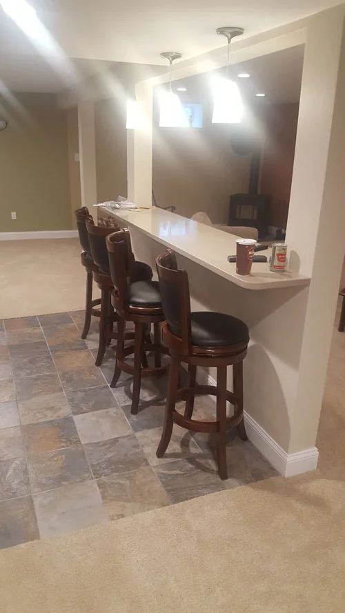 Finished basement with a built-in bar counter and stools