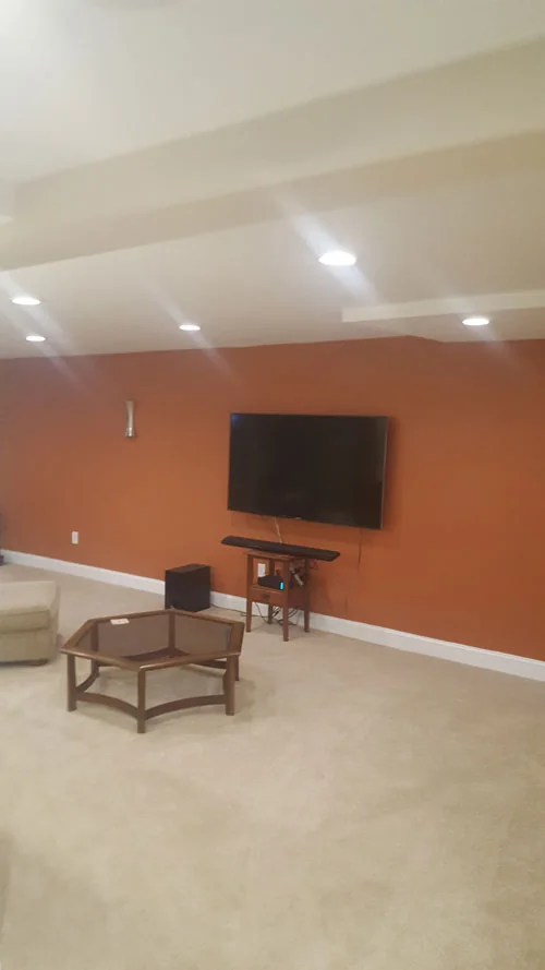 Finished basement media room with a wall-mounted TV