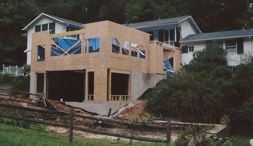 Two-story addition under construction with new framing and sheathing