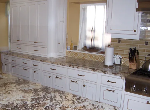 White kitchen cabinetry with granite counters and a tiled backsplash